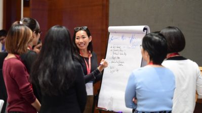 Women working together on a poster board.