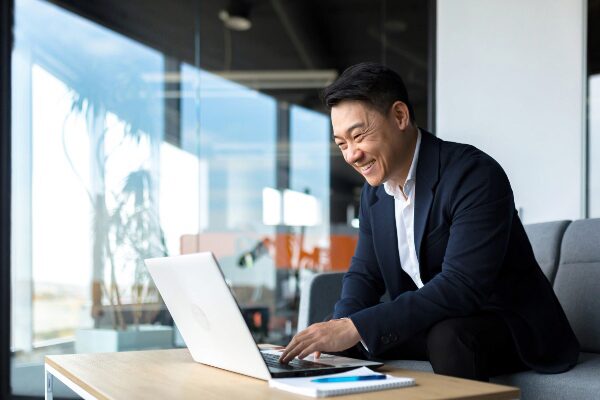 Smiling man working on a laptop