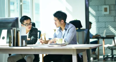 Two men working together in an office.