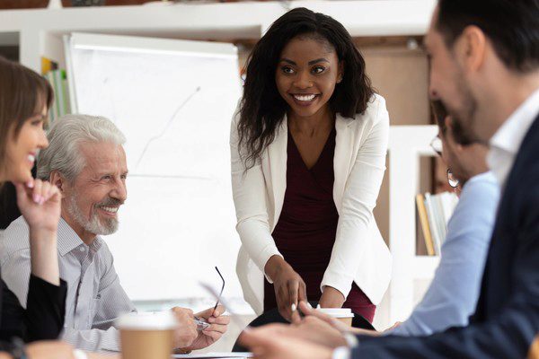  smiling management team gathered around a conference table