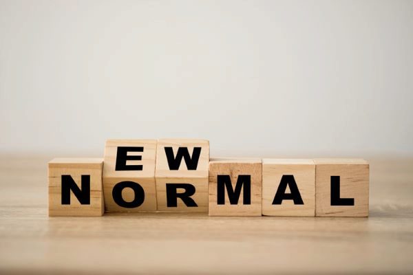 wooden blocks flipping to spell “new normal”