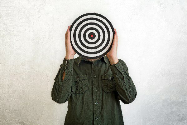 Man holding a target centered in front of his face