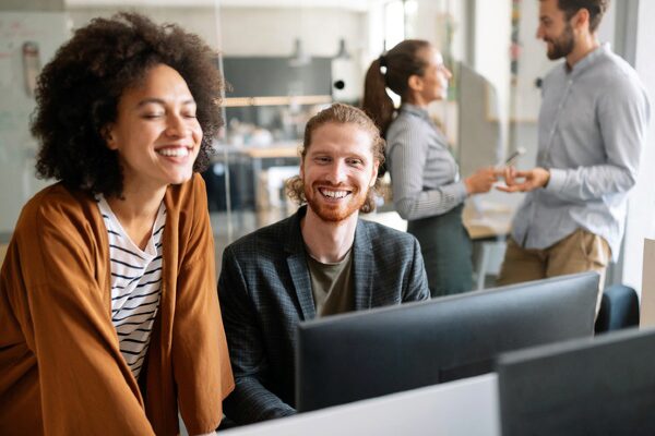 Business analysts collaborating at an office computer