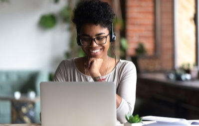 Woman sitting listening to an online lecture on her computer. 