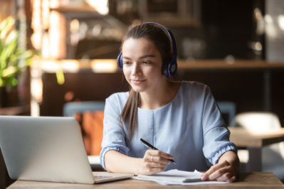 woman with headphones on in front of laptop