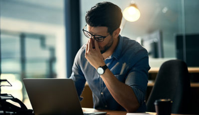 Shot of a young businessman experiencing stress during a late night at work