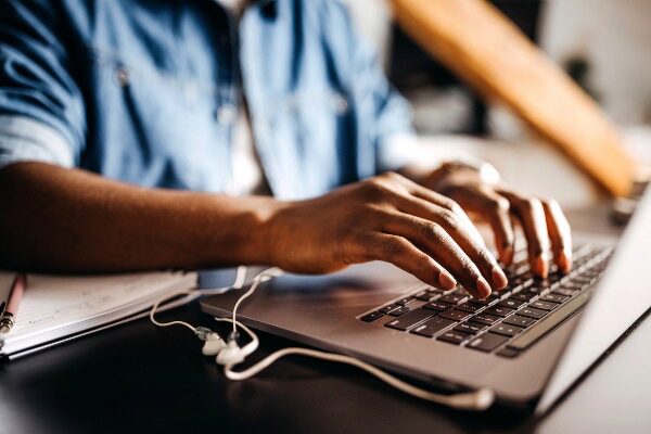 Close up of young man using a laptop at home