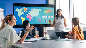 Woman leading a team meeting and pointing to a world map