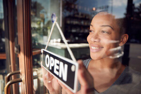 A small business owner opens her store for the day