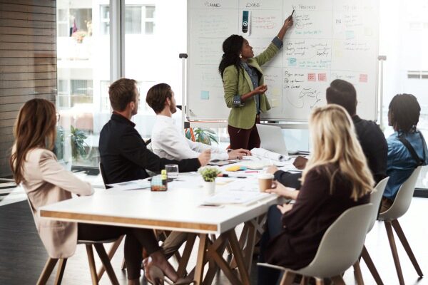 Businesswoman giving a presentation to her colleagues on a whiteboard